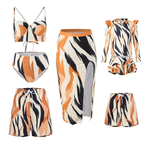 Flat lay of tiger print family swimwear set including bikinis, swim trunks and sun shirts