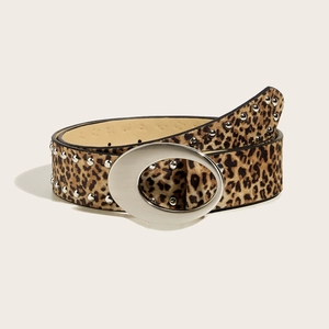 Gros plan sur une ceinture léopard avec boucle ovale argentée et rivets sur fond beige