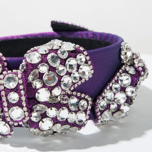 Détail macro du serre-tête en satin violet orné de strass étincelants denses