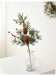 Artificial Christmas pine branch with pine cones and red berries in a glass vase