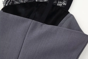 Detalle de tela tejida gris y encaje floral negro en un vestido ajustado de mujer