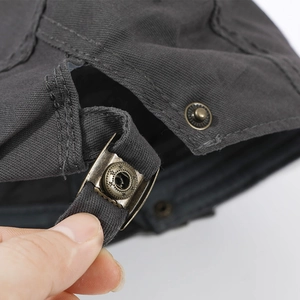 Detail of adjustable strap and vintage bronze buckle on dark gray cotton beret hat