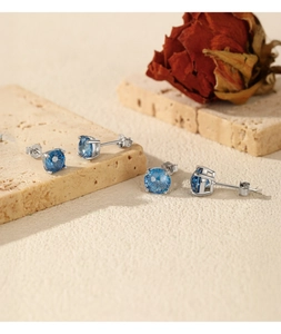 Macro detail of S925 sterling silver studs with blue round-cut sparkling gemstones