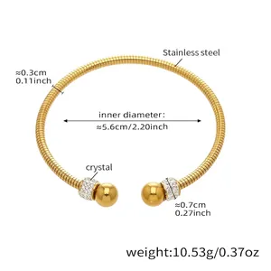 Detalle de brazalete dorado de acero inoxidable con textura de serpiente y cristales