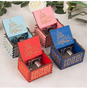 Detailed view of four colorful wooden hand-crank music boxes with Happy Birthday engraving