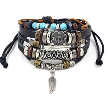 Detail view of multilayer leather bracelet featuring anchor motif and leaf pendant charm