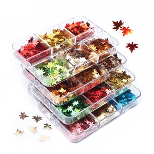 Stack of 6-grid boxes with maple leaf sequins in metallic laser colors on white backdrop
