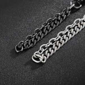 Macro shot of interlocking black and silver titanium steel chain links on dark surface