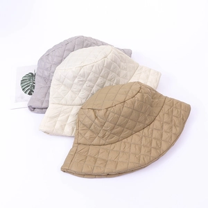 Three quilted bucket hats in grey, beige and khaki colors with a minimalist layout