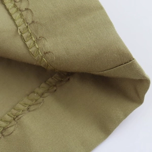 Close-up of khaki twill fabric showing professional stitching and hem finish