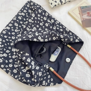 Vue détaillée du sac cabas en toile fleurie avec fermeture magnétique et poche zippée pratique