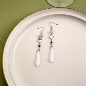 Detailed view of silver neo-Chinese earrings with green beads and white water drop pendants