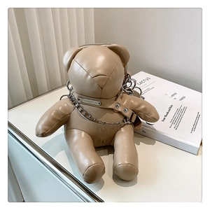Detail of cute bear-shaped PU leather crossbody bag with silver chain on a stylish counter