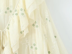 Vista macro del ricamo floreale verde e del tessuto in chiffon a balze con coulisse