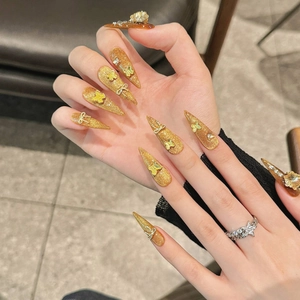 Golden glitter press-on nails with 3D yellow butterflies and silver bows on stiletto tips