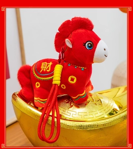 Close-up detail of a red plush horse zodiac mascot standing on a traditional golden ingot