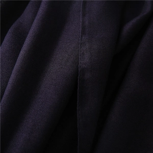 Primer plano de tela de lino violeta oscuro con tejido crepé fino y costura precisa