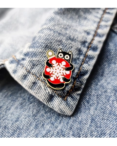 Detail einer Cartoon-Weihnachtsnadel mit schwarzer Katze an einem Jeanskragen
