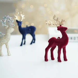 Detail of red flocked reindeer ornament with glitter antlers in a festive setting