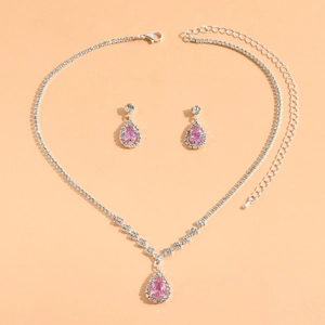 Detail view of silver necklace and earrings set with pink pear-shaped rhinestones