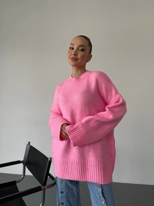 Cozy oversized pink crewneck knit sweater for women styled with light blue jeans