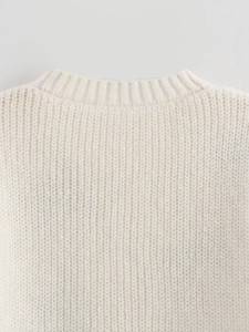 Detailansicht des gerippten weißen Strickpullovers mit Fokus auf den Nackenbereich