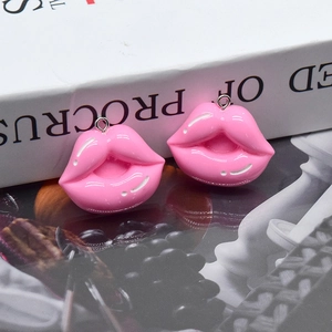 Vista macro detallada de dos dijes de labios de resina rosa brillante con ganchos de metal para DIY