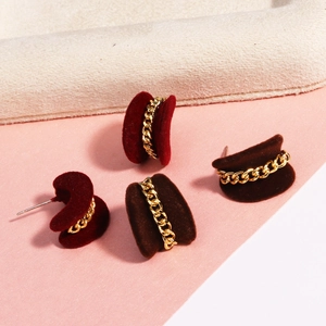 Detail of red and brown velvet heart earrings with elegant gold chain decoration