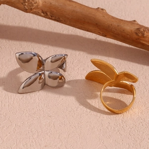 Polished 18K gold and silver butterfly floral open rings on a natural wood branch