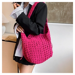 Dettaglio di una borsa tote all'uncinetto rosa con trama a maglia traforata di qualità