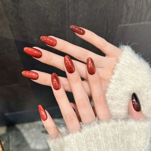 Red cat eye press-on nails in long almond shape with sparkling glitter effects