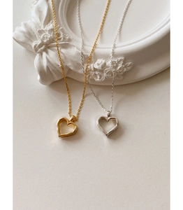 Macro detail of gold and silver hollow heart pendants on elegant relief frame