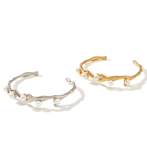 Streamlined minimalist pearl bangle in gold and silver finish with elegant metallic texture