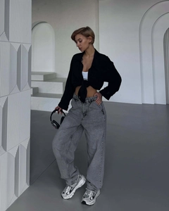 Street style shot of wide-leg washed grey denim jeans paired with black shirt and silver shoes
