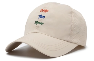 Detail of beige quick-dry baseball cap with colorful letter embroidery and breathable mesh