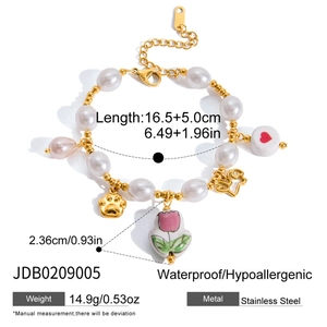 Detail of stainless steel charm bracelet with pearls and tulip pendant features