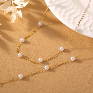 Elegant gold plated titanium steel necklace featuring white round shell pearls on brown leather