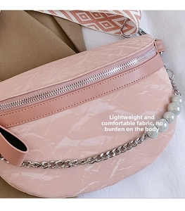 Detail of pink marble textured crossbody bag with silver chain and geometric strap