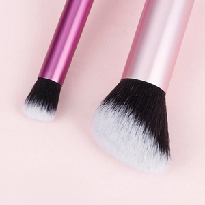Close-up of soft synthetic bristles and matte pink metallic handles of makeup brushes