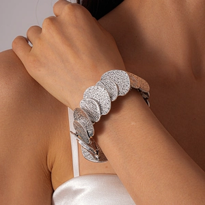 Minimalist silver pleated geometric disc bracelet with rock texture on female model