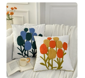 Close-up of tulip embroidery cushions with textured loop stitching on soft fabric