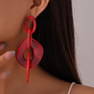 Close-up of red acrylic chunky chain link drop earrings on model with side view
