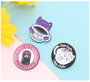 Detailed macro of three cute cat enamel pins featuring unique creative badge designs