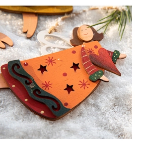 Close-up of hand-painted wooden angel ornament with heart detail on faux snow