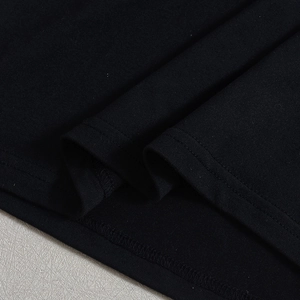 Close-up of the black knit fabric with detailed double stitching on the sexy cutout top
