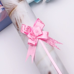 Macro shot of pink plastic pull bow with floral pattern for gift wrapping decoration