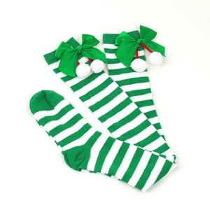 Close-up of green and white striped Christmas over-knee socks with bows and pom-poms