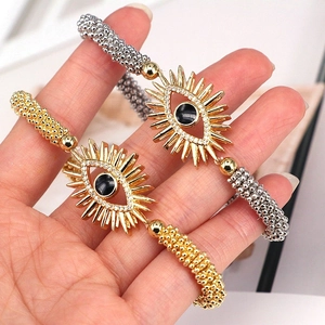 Detailed view of gold and silver evil eye beaded bracelets with crystal pave charms