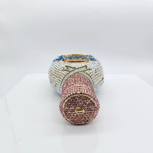 Detail of crystal bottle clutch bag showing pink gemstone cap and intricate diamond patterns