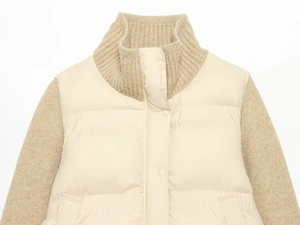 Close-up of cream knit stitching and quilted texture on a stand collar jacket
